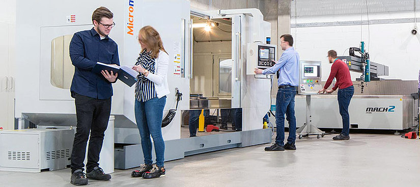 Ingenieure vor einer CNC-Maschine.