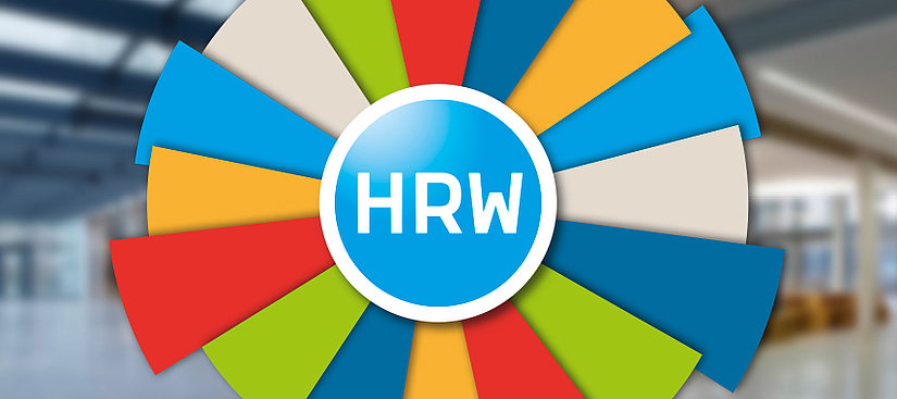 im Vordergrund ist eine bunte Drehscheibe zusehen. In der Mitte befindet sich ein blaues Kreis mit weissem Rand und in der Mitte steht in Großbuchstaben HRW.